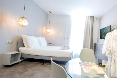 a small room with a bed and a glass table at The Den Newly Build Apartment 7-Minutes From Rotterdam City Central Station app2 in Schiedam