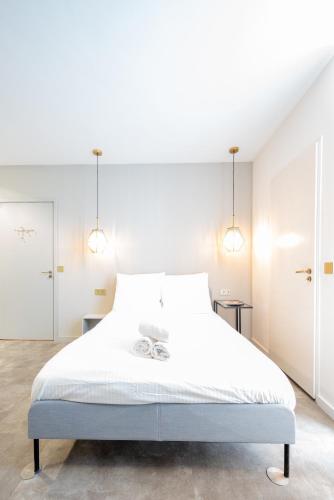 a bedroom with a large white bed with two lights at The Den Newly Build Apartment 7-Minutes From Rotterdam City Central Station app2 in Schiedam