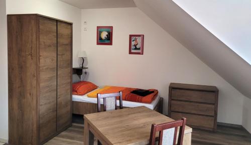 a room with a bed and a table and a bedroom at Penzion a wellness U Třeboňské madony in Třeboň