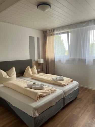two beds sitting in a bedroom with a window at Hubertus-Hof in Werne an der Lippe