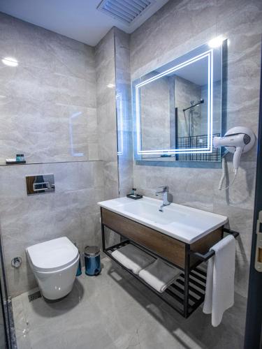 a bathroom with a sink and a toilet and a mirror at İncipark Hotel in Sakarya