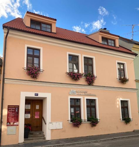 a building with flowers on the windows of it at Penzion a wellness U Třeboňské madony in Třeboň