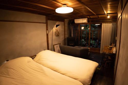 um pequeno quarto com uma cama e uma janela em 六根ゲストハウス Rokkon guest house em Quioto