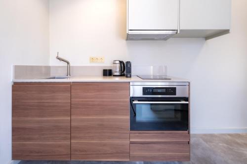 een keuken met een wastafel en een fornuis bij Luxurious Penthouse Newly Build just 7-Minutes from Rotterdam CS City app3 in Schiedam