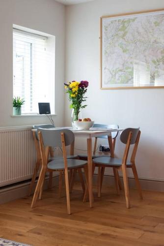a table and chairs with a vase of flowers on it at Y Cwtsh in Llandeilo