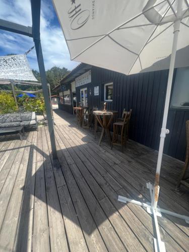 an umbrella on a deck with tables and chairs at CAMPING Bassin Arcachon - LES GOELANDS in Arès