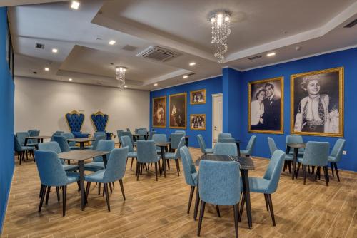 a room with tables and chairs and paintings on the walls at Montenegrina Hotel & SPA All-Inclusive in Becici