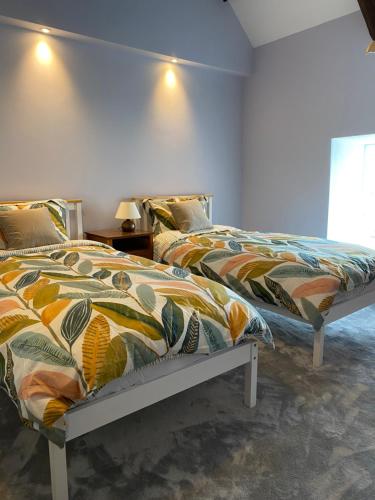 a bedroom with two beds with colorful blankets at Contemporary living with amazing views. Pembrokeshire in Pembrokeshire