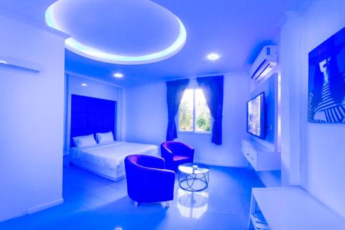 a bedroom with a bed and two chairs and a table at titanic residence in Pattaya Central