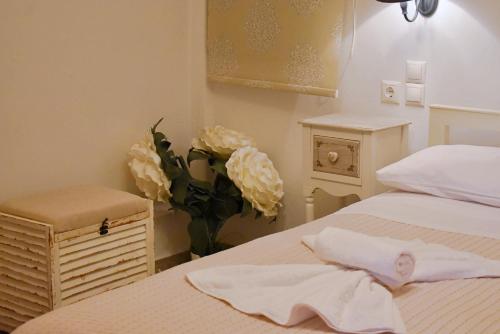a bedroom with a bed and a vase of flowers at Tzamaros Studios in Mérikhas