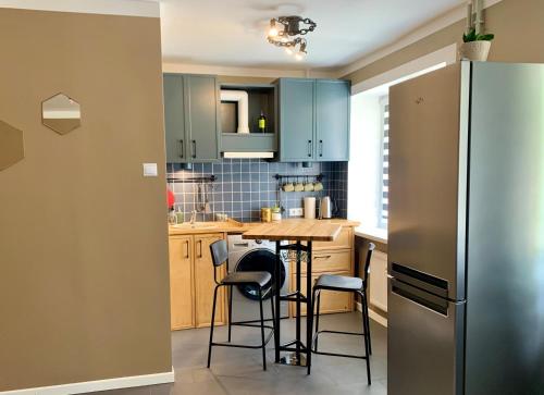 La cuisine est équipée d'une table, de chaises et d'un réfrigérateur. dans l'établissement Apartment Sigulda, à Sigulda