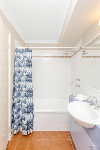 a bathroom with a sink and a shower curtain at Nautica Residences Hillarys in Perth