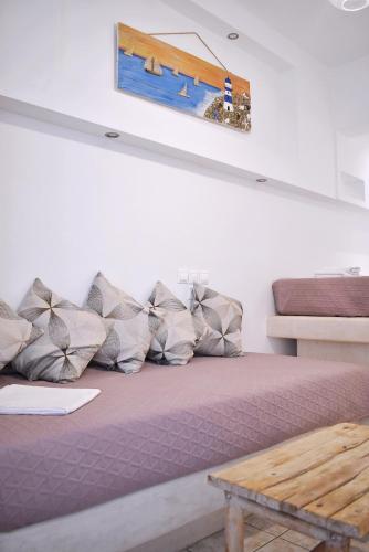 a couch with pillows and a painting on the wall at Tzamaros Studios in Mérikhas