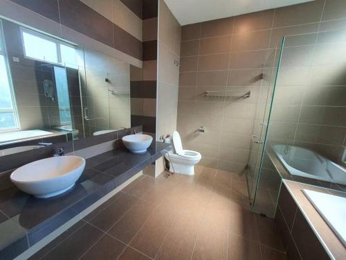 a bathroom with two sinks and a toilet and a shower at Villa near Bukit Indah / Eco Botanic / Legoland / Horizon Hill in Gelang Patah