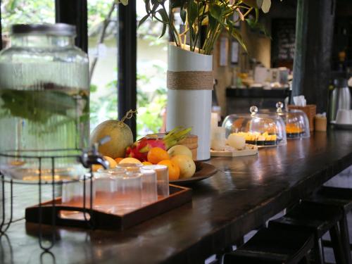a table with fruit and a vase on it at The Bivou Lijiang in Lijiang