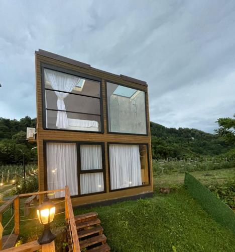 ein Haus mit einem großen Fenster auf dem Rasen in der Unterkunft Pano Blueberry in Namlisevi