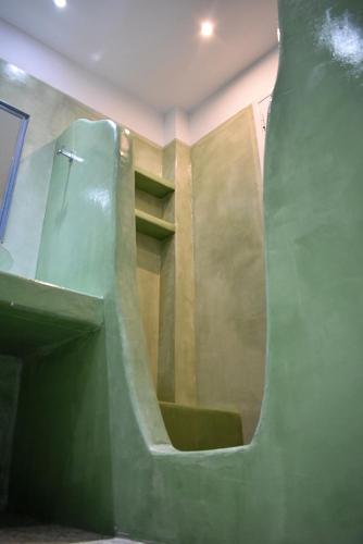 a bathroom with a slide in a green room at Tzamaros Studios in Mérikhas
