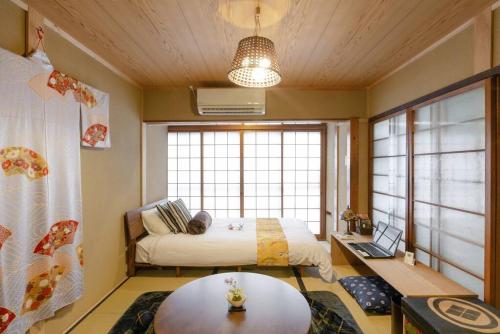 a bedroom with a bed and a table in a room at Nijo Castle, Kinkakuji.etc 西陣・京町家の宿「三石」 in Kyoto