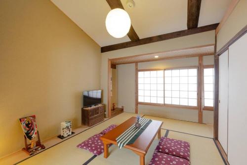 a living room with a table and a tv at Nijo Castle, Kinkakuji.etc 西陣・京町家の宿「三石」 in Kyoto