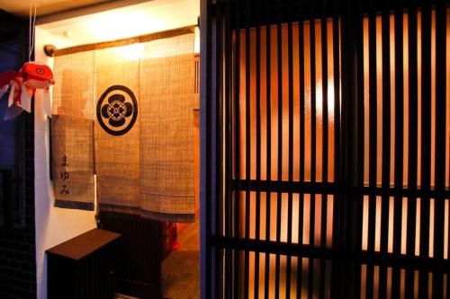 a door to a room with a sign on a wall at Nijo Castle, Kinkakuji.etc 西陣・京町家の宿「三石」 in Kyoto