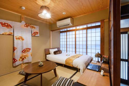 a bedroom with a bed and a table with a laptop at Nijo Castle, Kinkakuji.etc 西陣・京町家の宿「三石」 in Kyoto