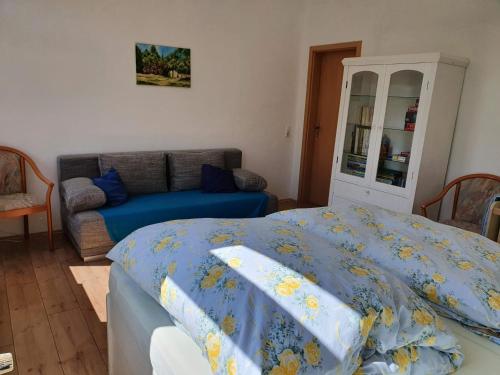 a bedroom with a bed and a couch at Ferienwohnung Ost - Alte Schule Sachswitz in Greiz
