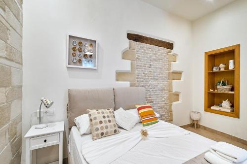 a bedroom with a bed and a brick wall at Semeli Apartment in Kissamos