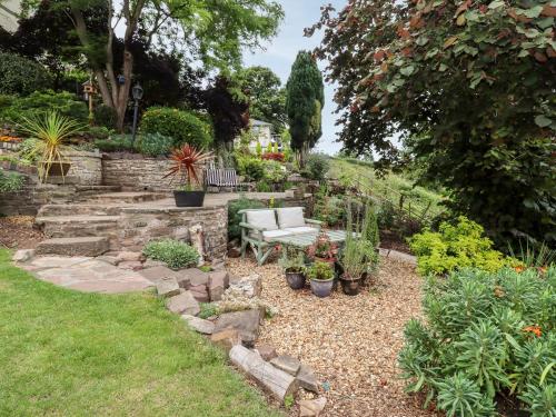 a garden with a bench and some plants at The Grooms in Lydney