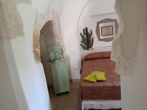 - une chambre avec un lit vert et une commode verte dans l'établissement Trullo Il cantagallo, à Locorotondo