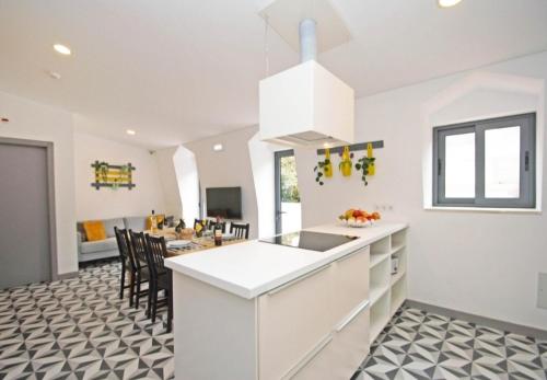 a kitchen with a white island and a dining room at In Downtown - Villa Serenity in Albufeira
