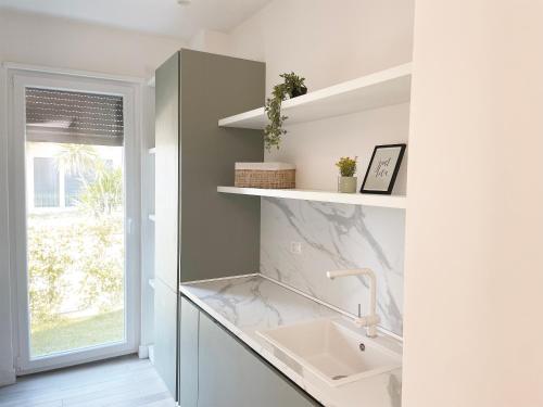 a bathroom with a sink and a window at Sea't La Vie Villas in Hamallë