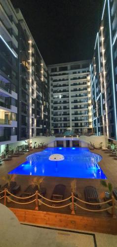 un grande edificio con una grande piscina blu di fronte di Studio NOAH a Mamaia Nord - Năvodari