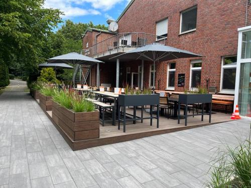 a patio with tables and umbrellas in front of a building at Apartment I , Netflix, Küche und Gym in Reken