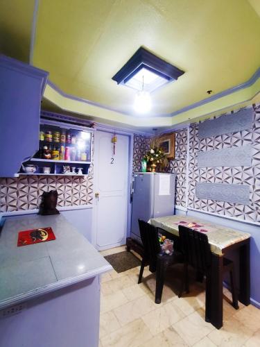 Il comprend une cuisine équipée d'une table et d'un réfrigérateur. dans l'établissement Cubao Quezon city Transient condo unit, à Manille