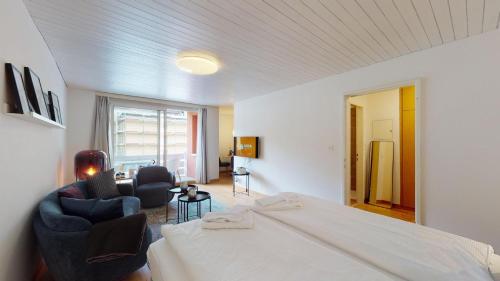 a hotel room with a bed and two chairs at Abitaziun Skyline 414 - St Moritz "LOGA ELEGANCE APARTMENT" in St. Moritz