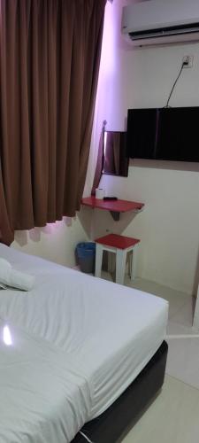 a bed in a room with a curtain and a table at Best Hotel Shah Alam @ UITM, i-City & Hospital in Shah Alam