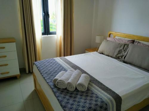 a bedroom with a bed with two towels on it at Ti Coco in Pereybere