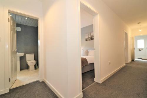 a bedroom with a bed and a bathroom with a toilet at Signature - Newbattle House in Chapelhall