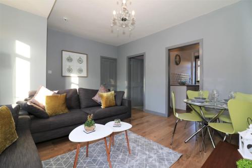 uma sala de estar com um sofá e uma mesa em Signature - Burnbank House em Hamilton