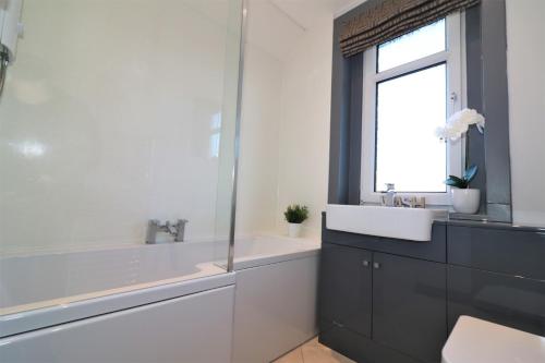 a bathroom with a sink and a window at Signature - Burnbank House in Hamilton