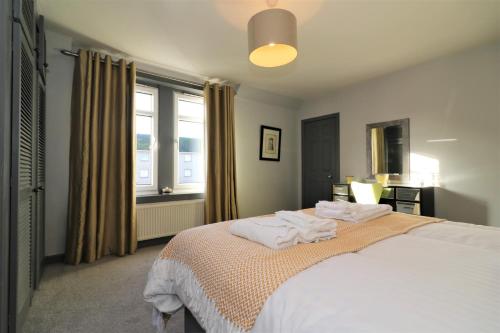 a bedroom with a bed with two towels on it at Signature - Burnbank House in Hamilton
