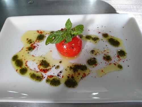 a white plate with a strawberry on top of broccoli at La Bella Donna in Ifaty