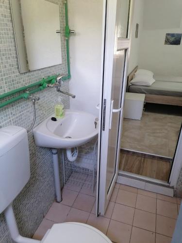 a bathroom with a sink and a toilet and a shower at Apartman Milan in Obrovac