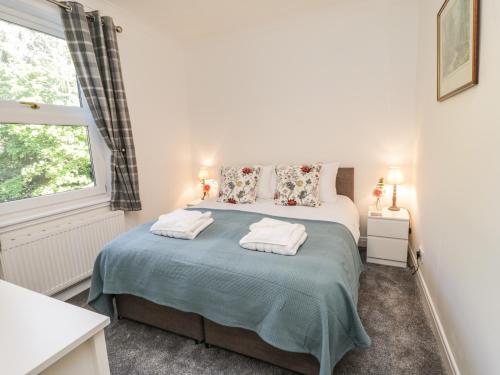 a bedroom with a bed with two towels on it at Woodend in Saltburn-by-the-Sea
