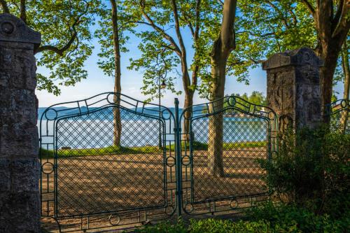 an iron gate with a field behind it at Hotel Anna Villa in Balatonföldvár