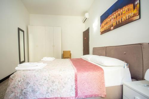 a bedroom with a bed with a pink and white blanket at Residenza Bra Apartment in Verona