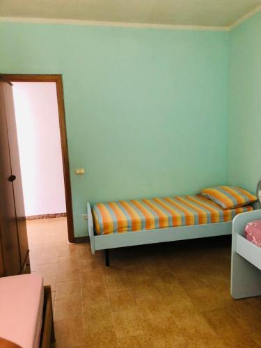 sypialnia z łóżkiem z pomarańczową i niebieską ścianą w obiekcie La Terrazza sul Mare w mieście Sellia Marina