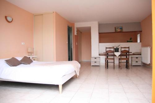 a bedroom with two beds and a dining room with a table at Studio in Pluduno