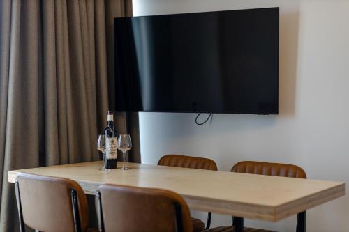 a table with wine glasses and a flat screen tv at The SPOT apartments - Orbi Beach Tower in Batumi