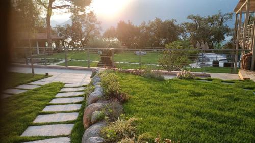 a garden with a stone path and a statue at Sibenbras Natural Aparthotel in Limone sul Garda